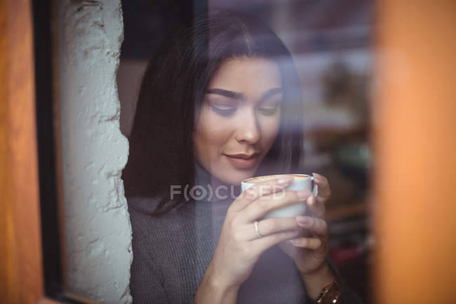 Красива жінка з чашкою кави в кафе — стокове фото