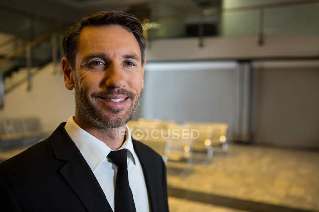 Portrait of smiling businessman standing in the airport terminal — Stock Photo