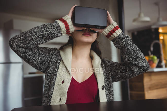Donna che utilizza auricolare realtà virtuale in soggiorno a casa — Foto stock