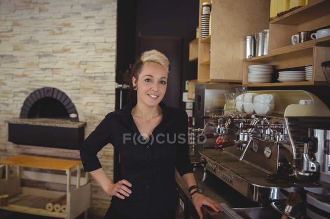 Retrato de la mujer de pie en la cocina en la cafetería - foto de stock