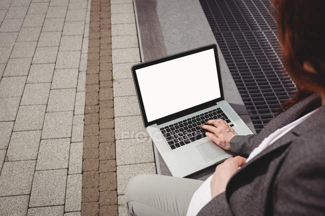 Femme d'affaires enceinte utilisant un ordinateur portable dans les locaux du bureau — Photo de stock