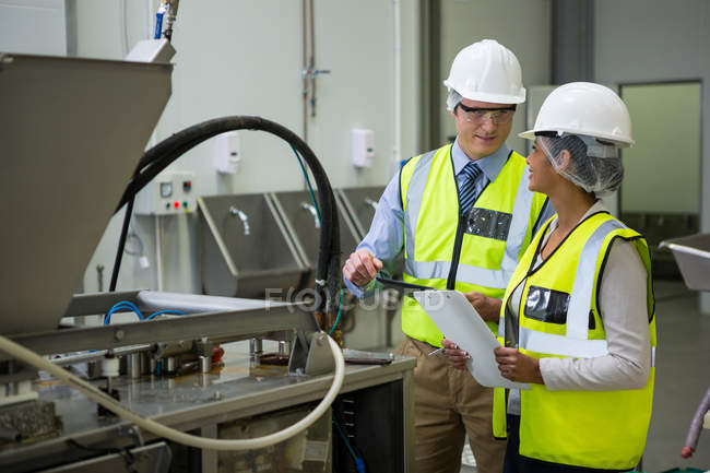 Techniker interagieren in der Fabrik miteinander — Stockfoto