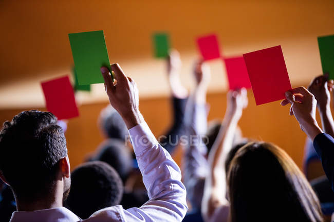 Vista posteriore dei dirigenti aziendali che mostrano approvazione alzando le mani al centro congressi — Foto stock
