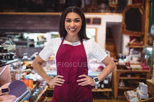 Porträt weiblicher Mitarbeiter, die mit der Hand auf der Hüfte im Supermarkt stehen — Stockfoto