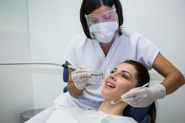Zahnarzt untersucht Patientin mit Werkzeug in Zahnklinik — Stockfoto