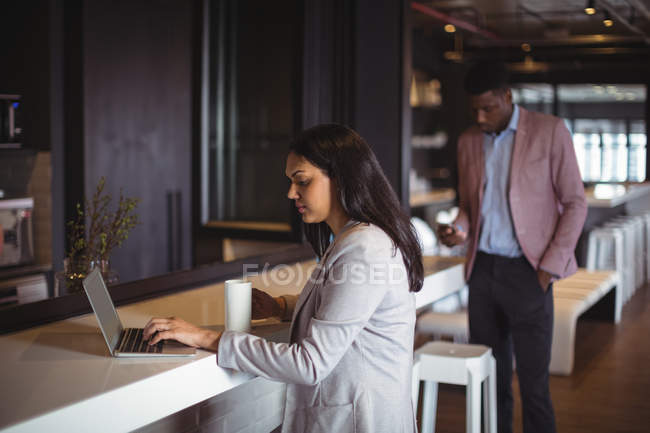 Businesswoman working over laptop in office — Stock Photo