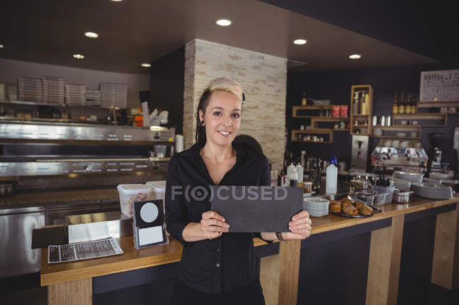 Portrait of woman holding tray in kitchen at cafe — Stock Photo
