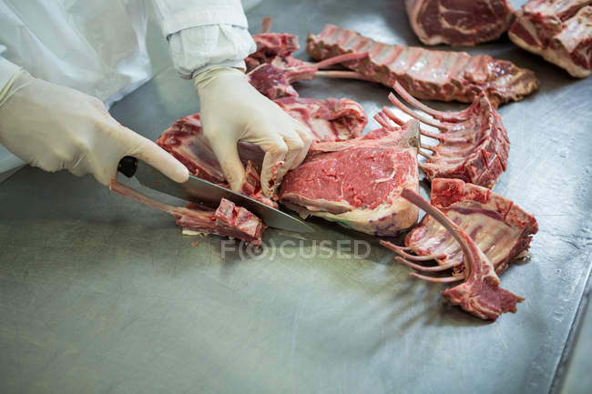 Schlachter schneidet Fleisch in Fleischfabrik — Stockfoto