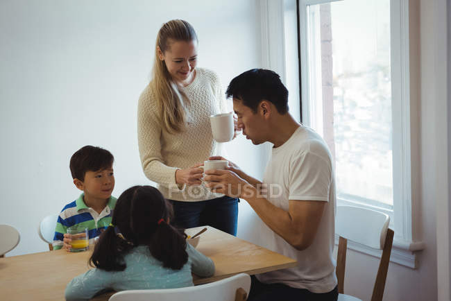 Woman serving coffee to man at home — Stock Photo