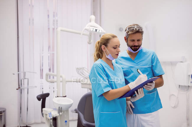 Dentistas interagindo uns com os outros na clínica dentária — Fotografia de Stock