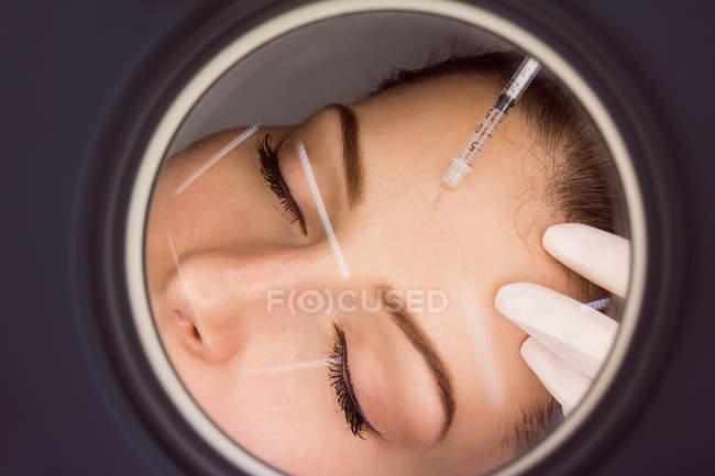 Jovem paciente do sexo feminino recebendo injeção estética no rosto na clínica estética — Fotografia de Stock