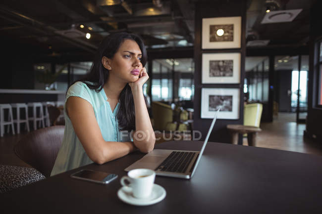 Upset businesswoman sitting at her desk in office — Stock Photo