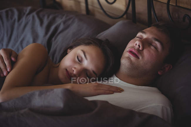 Пара спит на кровати в спальне дома — стоковое фото