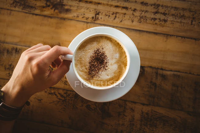 Mãos de mulher segurando xícara de café no café — Fotografia de Stock
