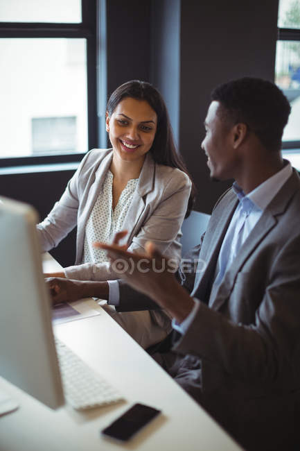 Businessman and a colleague working over computer in office — Stock Photo