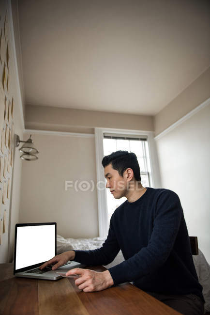 Чоловік робить онлайн покупки на ноутбуці вдома — стокове фото