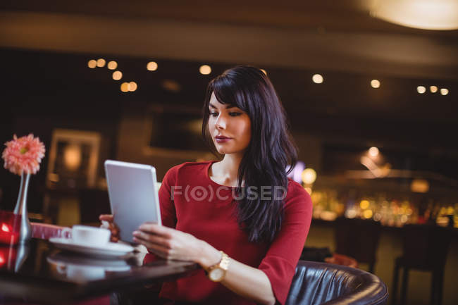 Woman using digital tablet in restaurant — Stock Photo