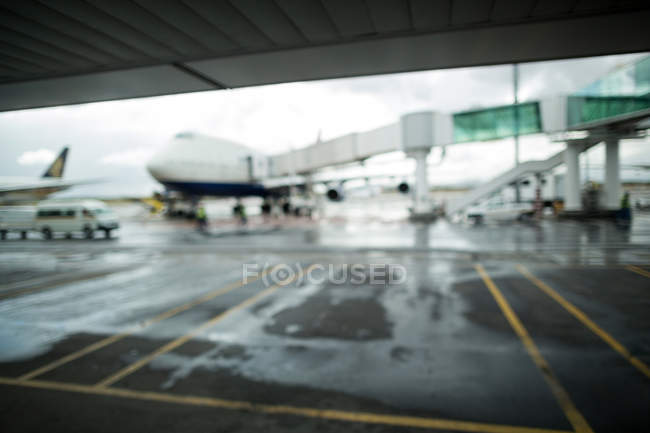 Avião estacionado na pista no terminal do aeroporto — Fotografia de Stock