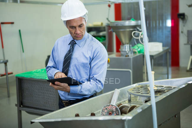 Técnico inspecionando enquanto estiver usando tablet digital na fábrica de carne — Fotografia de Stock
