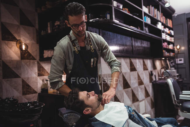 Barber putting towel over client in barber shop — Stock Photo