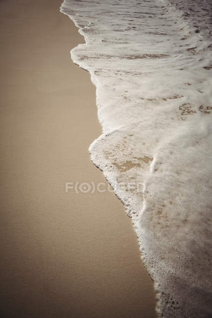 Gros plan sur le surf d'eau de mer sur sable de plage — Photo de stock