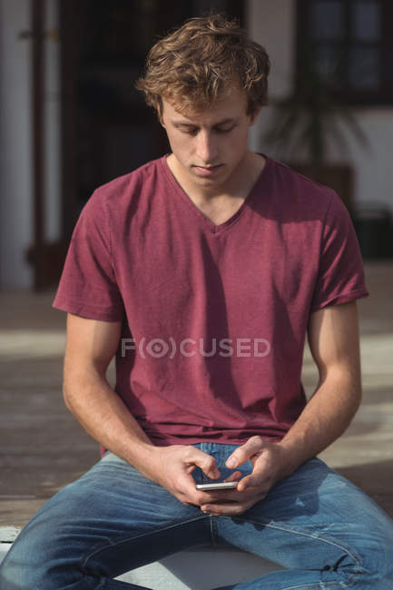 Man sitting on porch and using mobile phone at home — Stock Photo