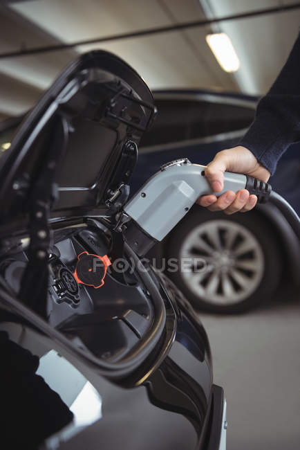 Close-up of man charging car at electric vehicle charging station — Stock Photo