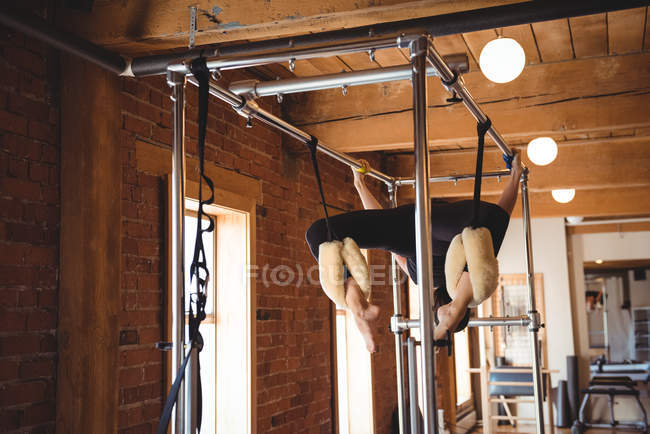 Fit mulher praticando pilates em equipamentos de exercício no estúdio de fitness — Fotografia de Stock