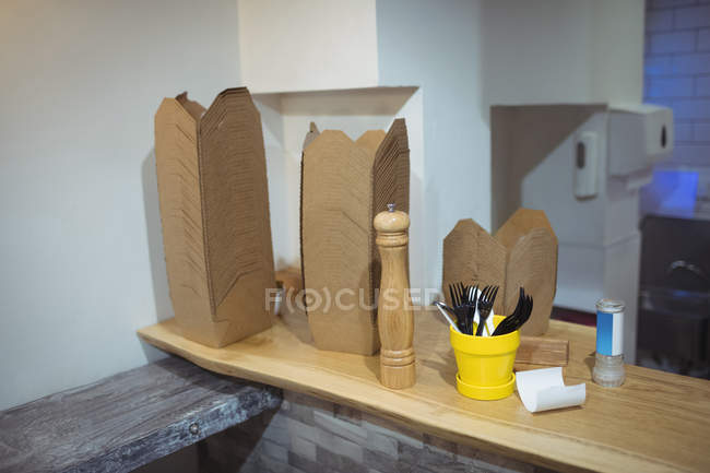 Cajas de papel apiladas en el mostrador en el interior del restaurante moderno - foto de stock