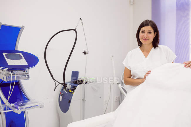 Retrato de dermatóloga femenina de pie en la clínica - foto de stock