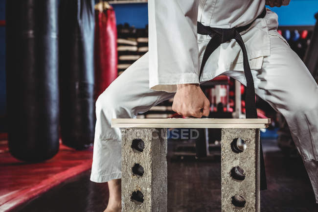 Karate giocatore rottura asse di legno in sala fitness — Foto stock