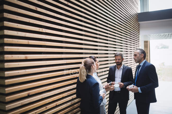 Empresários tomando chá e interagindo durante o tempo de pausa no escritório — Fotografia de Stock
