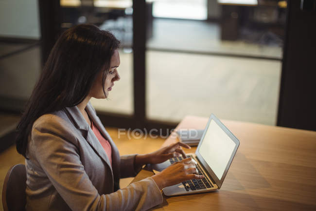 Empresária trabalhando sobre laptop no escritório — Fotografia de Stock