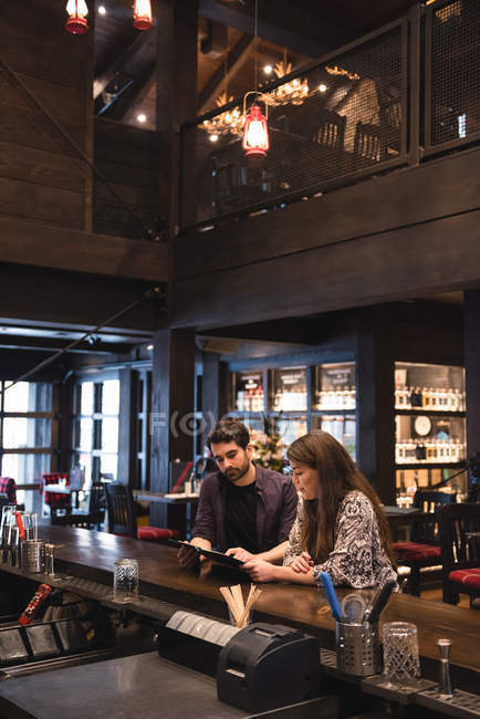 Couple discutant sur le menu au comptoir du bar — Photo de stock
