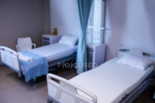 Розмитість зору порожній лікарняних ліжок в палаті лікарні — стокове фото