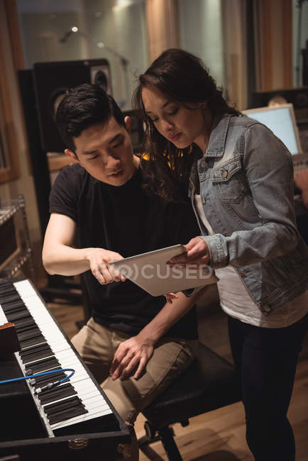Músicos discutindo sobre tablet digital no estúdio de música — Fotografia de Stock