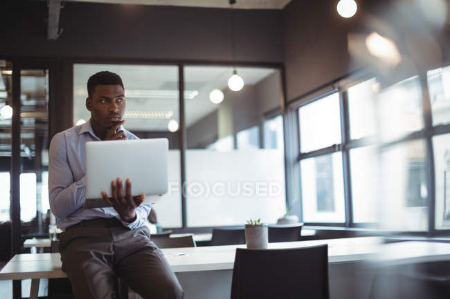 Розумний бізнесмен працює над ноутбуком в офісі — стокове фото