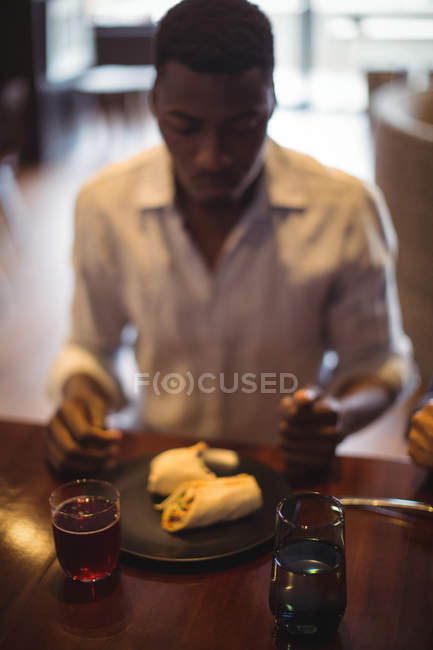 Hombre comiendo en el restaurante - foto de stock