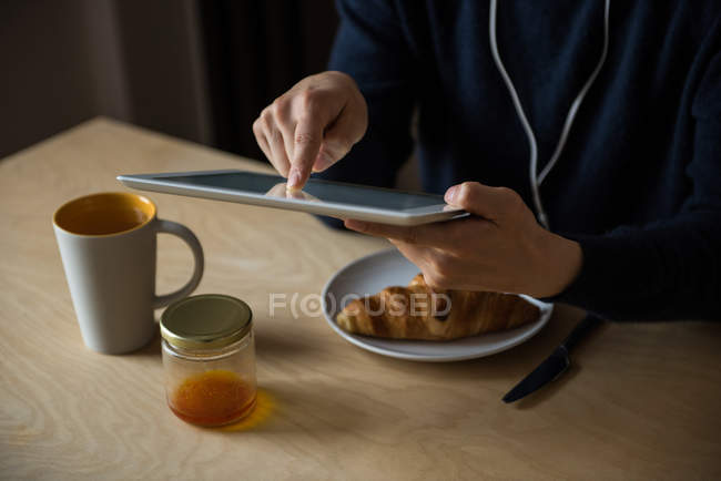Человек слушает музыку на цифровом планшете дома — стоковое фото