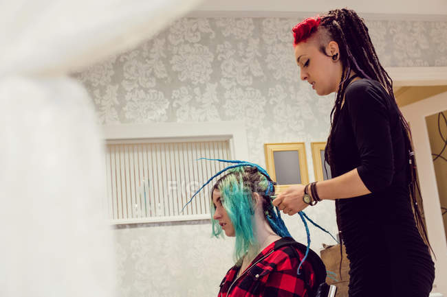 Kosmetikerin stylt Kunden Haare in Dreadlocks — Stockfoto