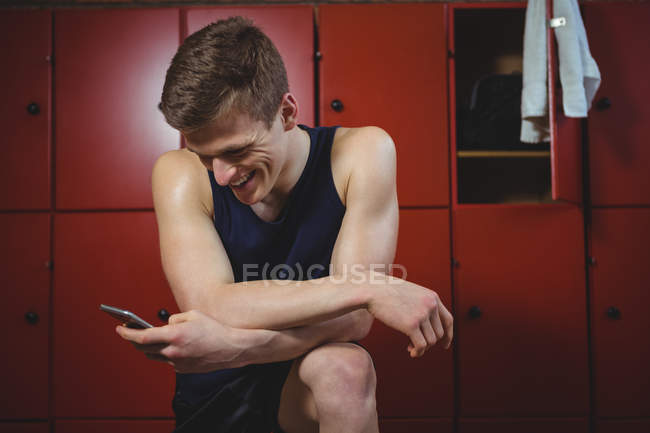 Sportler benutzt Handy in Umkleidekabine — Stockfoto