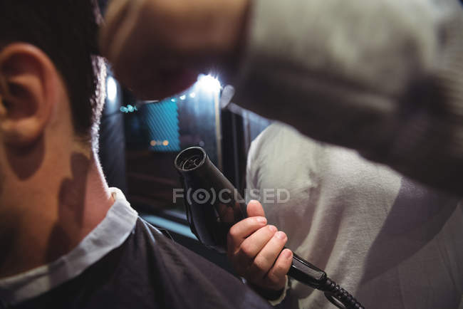 Mid section of barber blow drying client hair — Stock Photo