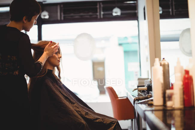 Женщина парикмахер укладки клиентов волосы в салоне — стоковое фото