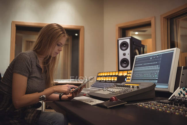 Audio engineer using digital tablet in recording studio — Stock Photo