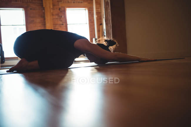 Женщина, практикующая йогу, позирует в фитнес-студии — стоковое фото