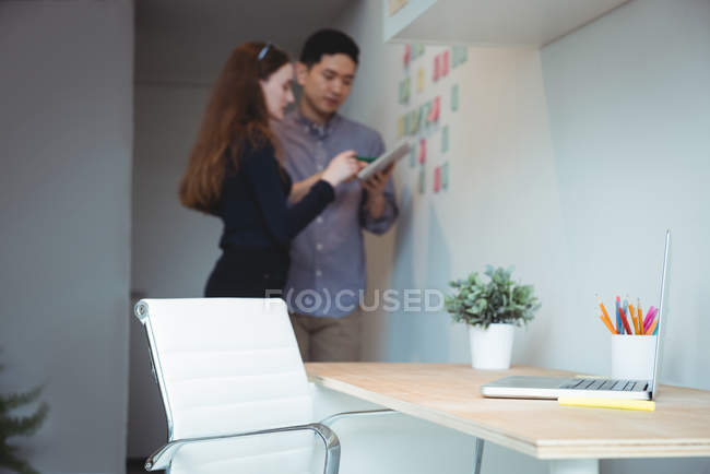 Керівники бізнесу обговорюють цифровий планшет в офісі — стокове фото