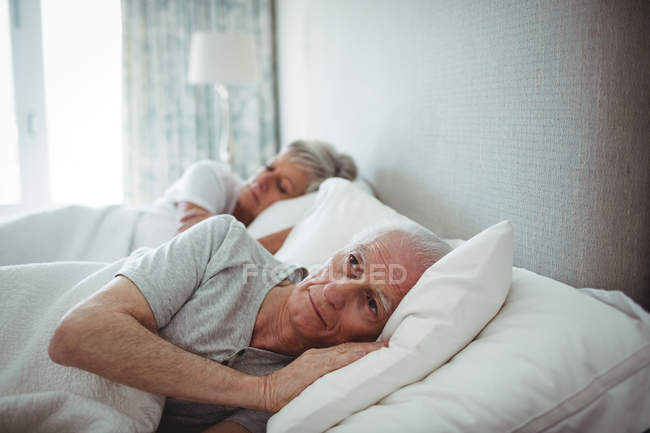 Casal sênior deitado na cama no quarto — Fotografia de Stock