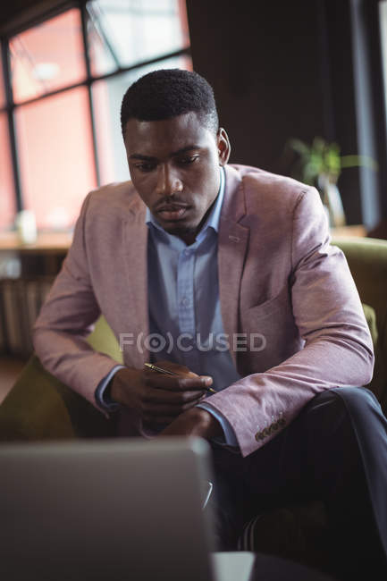 Businessman working over laptop in office — Stock Photo