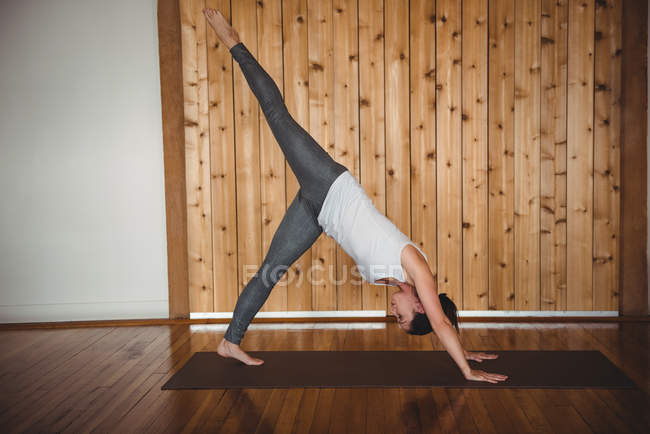 Metà donna adulta che pratica yoga in palestra — Foto stock
