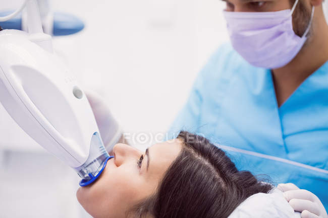Пациентка, получающая лечение зубов от мужского ортодонта в стоматологической клинике — стоковое фото